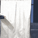 a person is holding a piece of paper in front of a white curtains