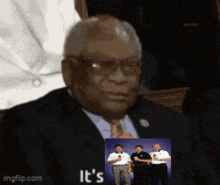 a man in a suit and tie has a picture of three men behind him and the words it 's on the bottom