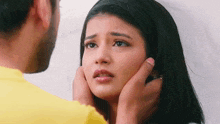 a man is touching the face of a woman who is looking at him .