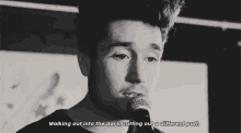a man is singing into a microphone with a quote .