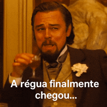 a man with a beard is holding a glass of wine and says a requia finalmente chegou