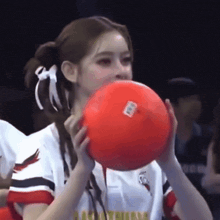 a cheerleader is blowing up a red ball with a sticker on it that says ' washington '