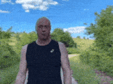 a man wearing a black tank top with asics on it