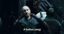 a man in a fur coat is talking about bolton swag .