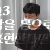 a man wearing a face mask is standing in front of a sign that says " 23 "