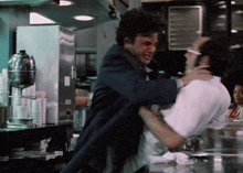 a man in a suit is holding another man in a white shirt