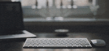 a keyboard and mouse sit on a desk in front of a window
