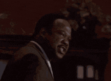a man in a suit is screaming with the words shhhhiiiiii written below him
