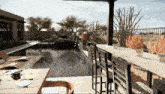 a computer generated image of a swimming pool with a table and chairs in the foreground