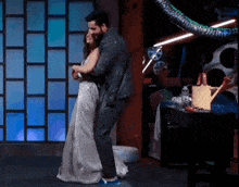 a man and a woman are dancing on a stage in a room .