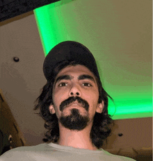a man with long hair and a beard wearing a baseball cap