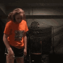 a girl in an orange shirt is dancing with a boy in a black hoodie .
