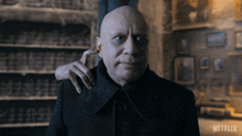 a bald man with a hand on his shoulder and a netflix logo on the bottom right