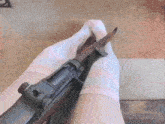 a person wearing pink socks holds a rifle