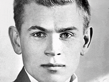 a black and white photo of a young man in a suit and white shirt .