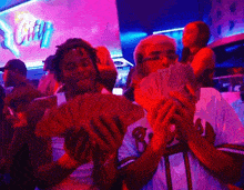 a man in a braves jersey holds a bunch of money