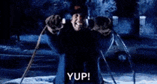 a person is standing in front of a fountain with a fireball coming out of it and the words `` yup ! ''