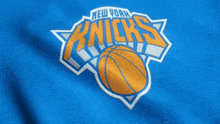 the new york knicks logo is on a blue shirt