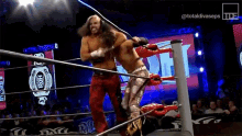 two men are wrestling in a ring with a large screen behind them that says totaldivaseps .