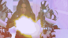 a woman is holding a gun in front of a robot with the letter t on it