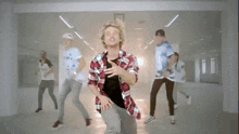 a group of young men are dancing together in a room .