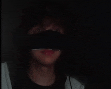 a close up of a person wearing a black mask in the dark .