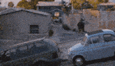 two cars are parked in front of a building with graffiti on it that says ' a few hill '