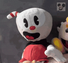 a stuffed cuphead with a red and white candy cane on its head