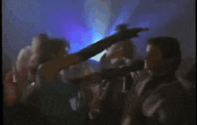 a group of people are dancing in a dark room