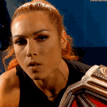 a woman with red hair is wearing a black tank top and a red belt