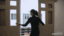 a woman stands in front of a door that says made in animatica