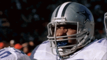 a football player wearing a silver helmet with a blue star on it