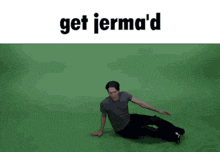 a man is laying on a green surface with the words get jerma 'd above him