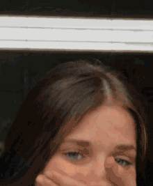 a close up of a woman 's face with a white light behind her