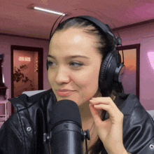 a woman wearing headphones stands in front of a microphone with the word on air behind her