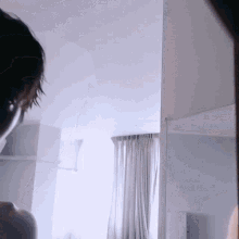 a woman is looking at herself in a mirror in a room