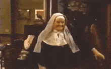 a nun is standing in a room with a cross on her head