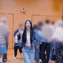 a woman with long black hair is standing in a crowd of people