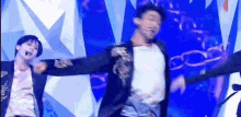 a group of men are dancing on a stage with their arms outstretched .