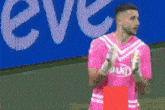 a soccer player wearing a pink shirt with dand on it