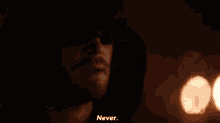 an arrow is wearing a hood and sunglasses and saying `` never '' in the dark .