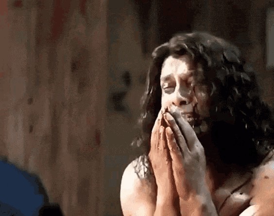 a man with blood on his face is praying