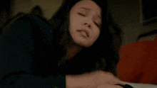 a woman laying on a bed with her eyes closed and her mouth open