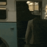 a man in a cowboy hat is getting on a bus .