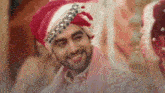 a bride and groom are smiling at each other while wearing a turban .