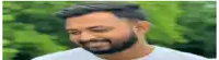 a man with a beard is smiling with his eyes closed .