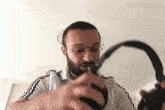 a man with glasses is holding a pair of headphones in his hands .