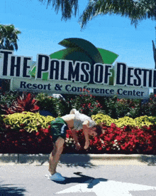 a man is doing a handstand in front of the palms of destiny resort and conference center