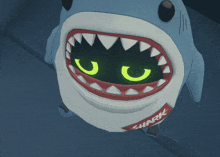 a shark with glowing eyes and the word shark on its shirt