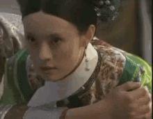 a woman in a green and white dress is being held by a man .
